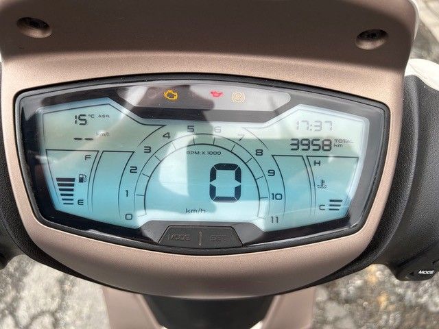 Das Armaturenbrett des Rollers zeigt einen Tachometer bei 0, eine Temperaturanzeige, eine Tankanzeige und einen Kilometerzähler mit einem Stand von 3958 km an.