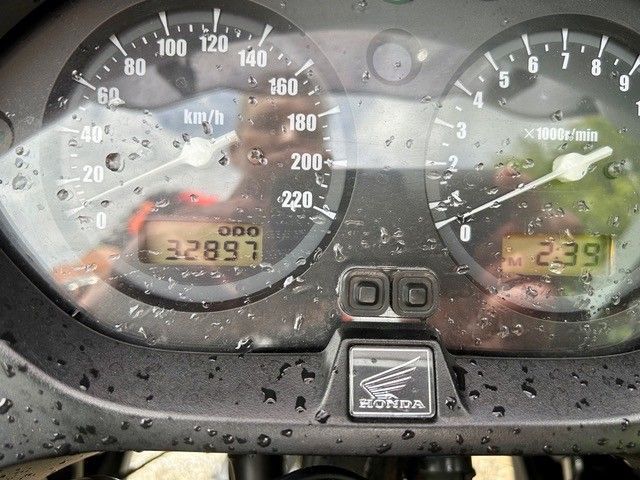 Motorrad-Armaturenbrett mit Tachometer, Kilometerzähler und nassen Anzeigen im Regen