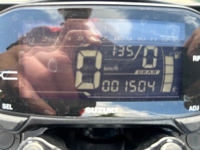 Nahaufnahme des digitalen Armaturenbretts eines Suzuki-Motorrads mit der Anzeige 0 mph und Kilometerstand 001504.