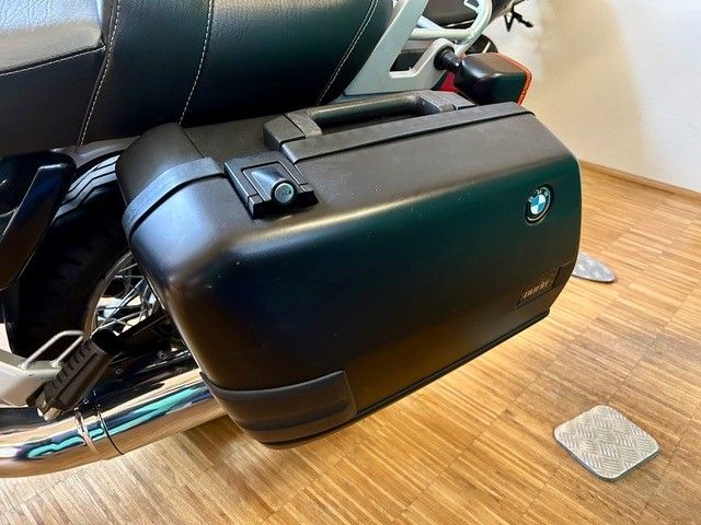 Ein Motorrad ist auf einem Holzboden in einem Raum geparkt.