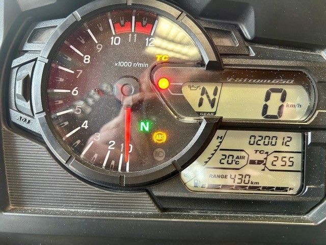 Motorrad-Armaturenbrett mit analogem Drehzahlmesser, digitaler Geschwindigkeitsanzeige und beleuchteten Warnleuchten; Gang im Leerlauf.