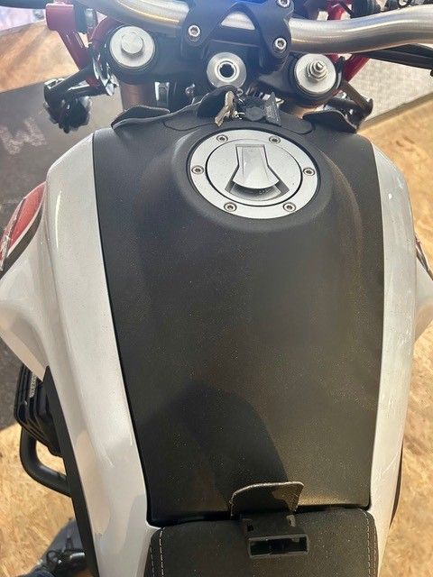 Draufsicht auf einen schwarz-silbernen Motorradtank und Lenker im Freien