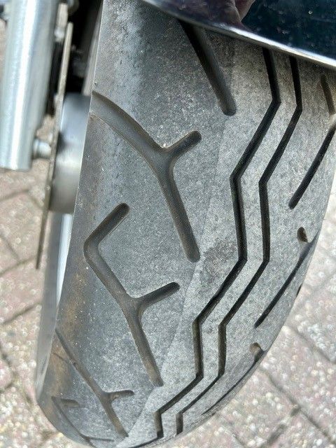 Eine Nahaufnahme eines Motorradreifens auf einer Ziegelsteinstraße.