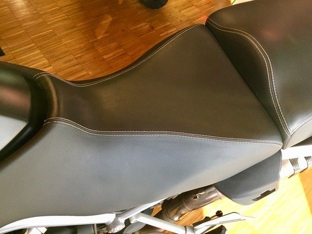 Eine Nahaufnahme eines Motorradsitzes auf einem Holzboden.