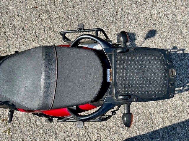 Draufsicht auf ein schwarzes Motorrad, das auf einer gepflasterten Fläche geparkt ist