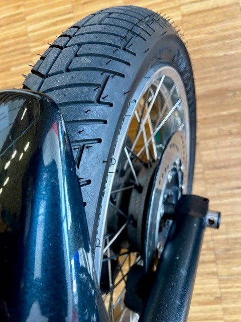 Eine Nahaufnahme eines Motorradreifens auf einem Holzboden