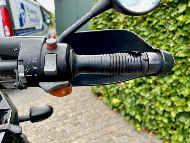 Motorradlenker mit Handschutz, Schaltern und Griff.