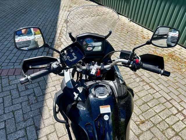 Motorradlenker und Armaturenbrett, von oben auf einer mit Ziegeln gepflasterten Straße gesehen