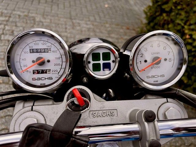 Motorrad-Armaturenbrett mit Tachometer, Drehzahlmesser und Kontrollleuchten; Silber und Chrom.