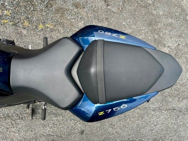 Draufsicht auf einen blau-grauen Motorradsitz auf Asphalt, beschriftet mit Z750.
