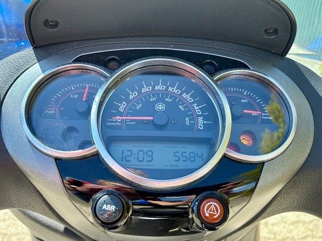 Eine Nahaufnahme des Armaturenbretts eines Motorrads mit Tachometer und Uhr.