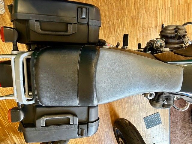 Auf einem Holzboden steht ein Motorrad mit einem Kofferraum auf der Ladefläche.