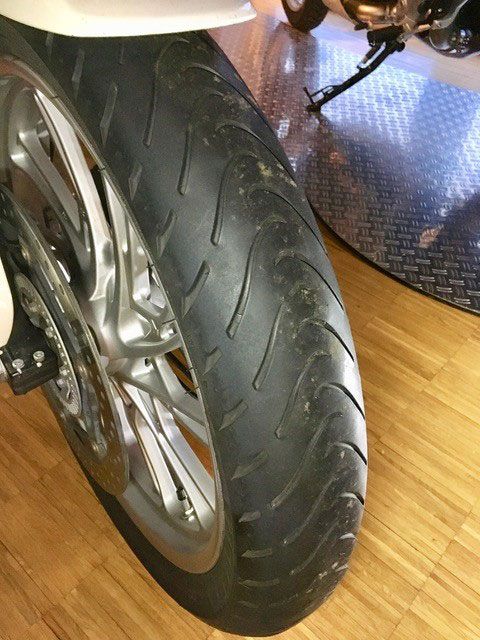 Eine Nahaufnahme eines Motorradreifens auf einem Holzboden
