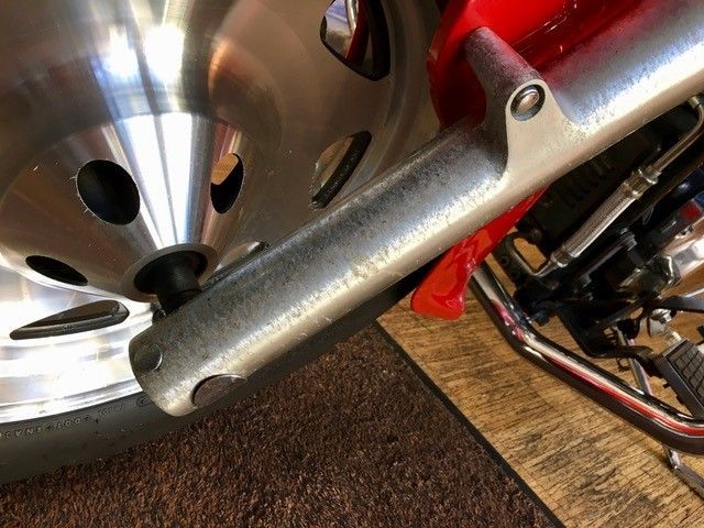 Eine Nahaufnahme eines Motorradrads und eines Auspuffrohrs.