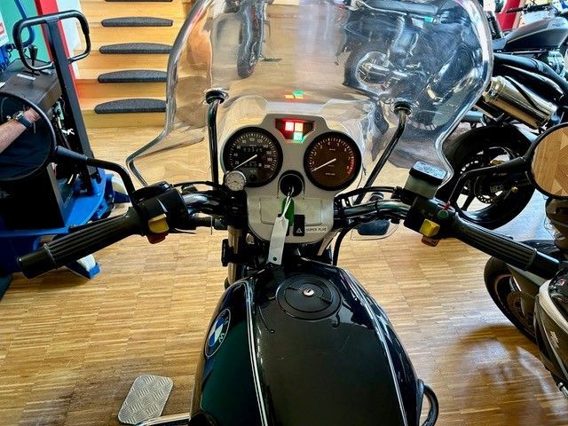 Ein Motorrad ist in einem Raum mit anderen Motorrädern geparkt.