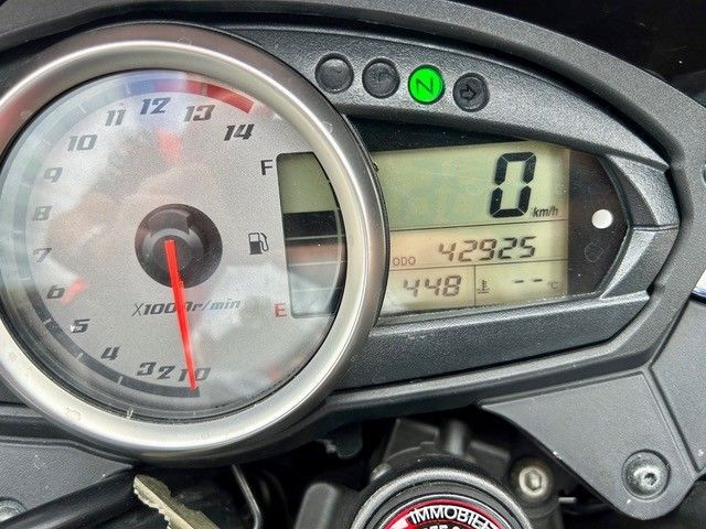 Das Motorrad-Cockpit zeigt Geschwindigkeit 0, Kilometerstand 42929 und einen fast leeren Tank an.