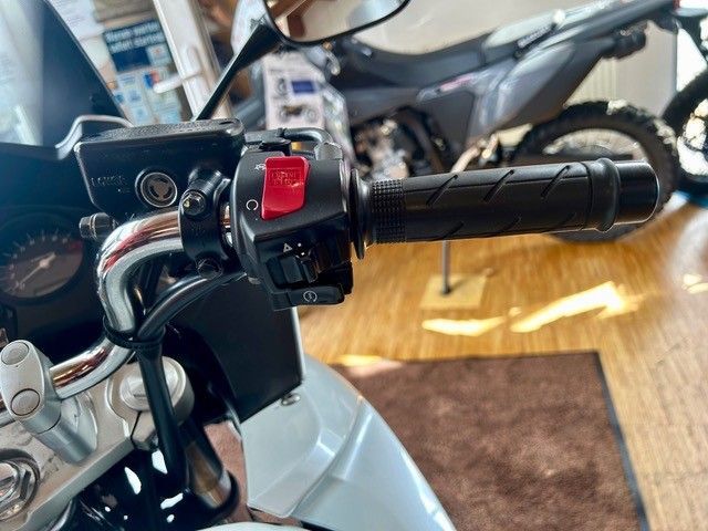 Motorradlenker mit rotem Schalter und schwarzem Griff in einer ausstellungsraumähnlichen Umgebung