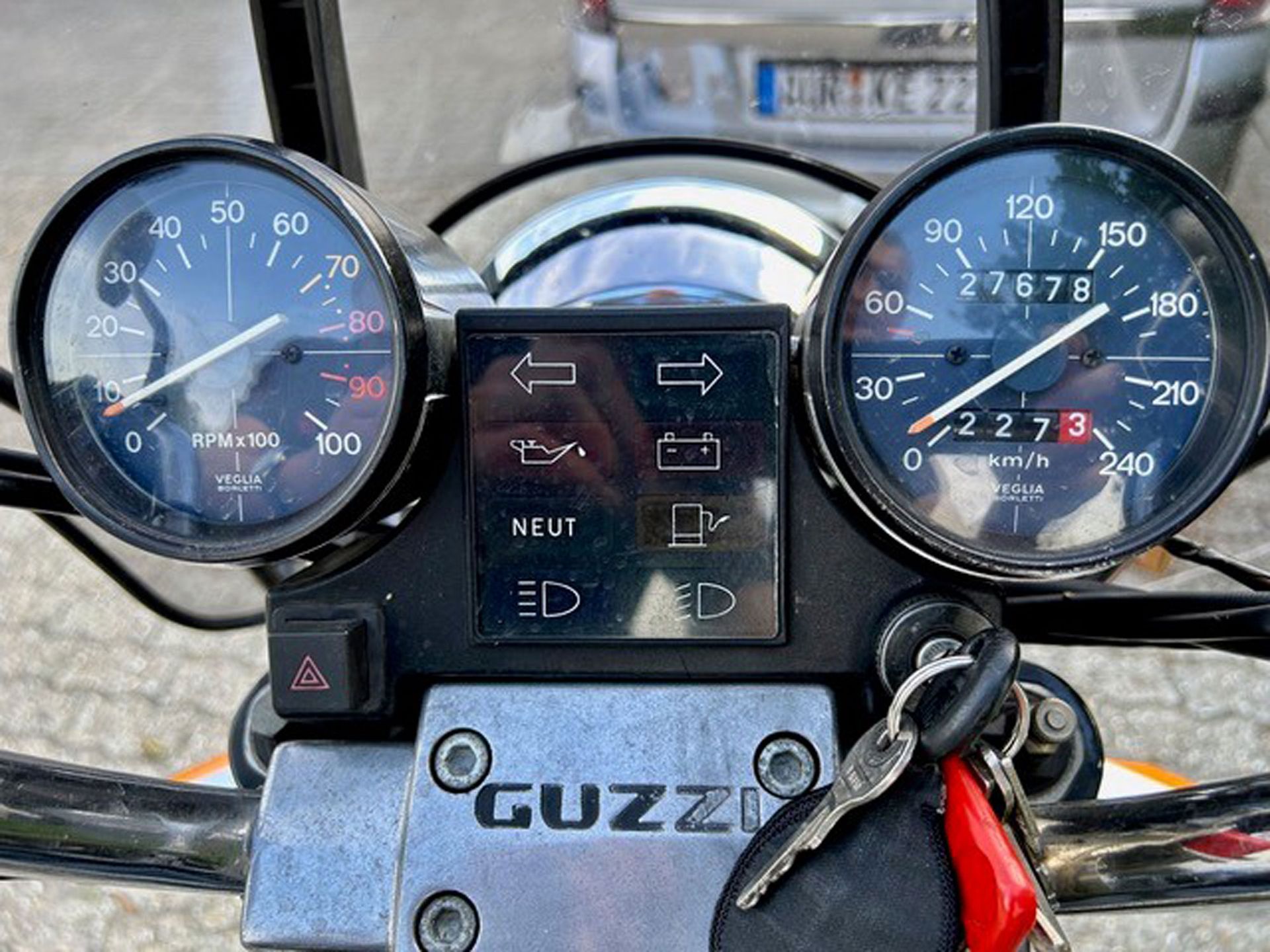Motorrad-Armaturenbrett mit Tachometer und Drehzahlmesser. Inklusive Warnleuchten und dem Markennamen „Guzzi“.