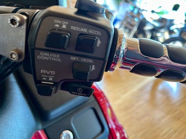 Nahaufnahme der Bedienelemente am Motorradlenker, einschließlich Tempomat und Rückwärtsgangschalter. Die Tasten sind schwarz mit weißer Beschriftung und Chromakzenten sind sichtbar.