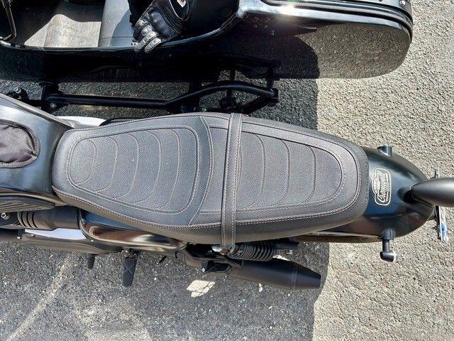 Schwarzer Motorradsitz mit angebautem Beiwagen.