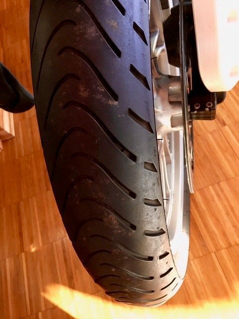 Eine Nahaufnahme eines Motorradreifens auf einem Holzboden