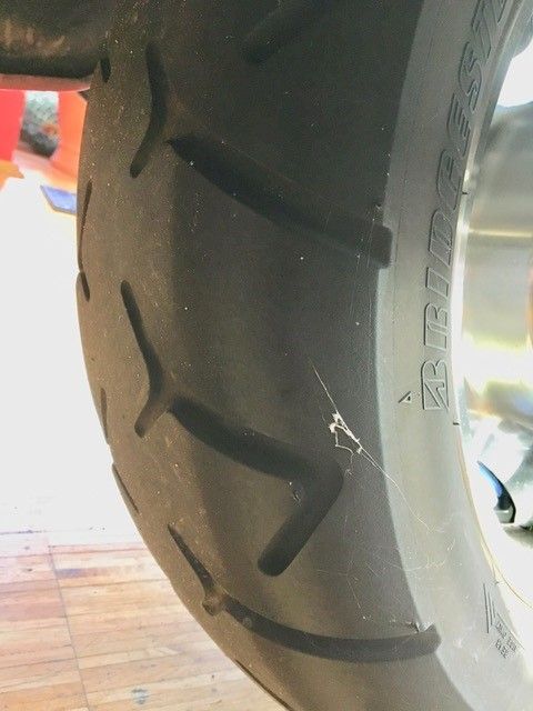 Eine Nahaufnahme eines Motorradreifens auf einem Holzboden.