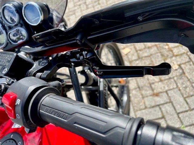 Motorradlenker mit rotem Schalter, Spiegeln und Instrumenten in Nahaufnahme