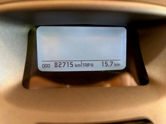 Auf dem Armaturenbrett des Autos ist ein Kilometerstand von 82.715 km und eine Fahrstrecke von 15,7 km zu sehen.