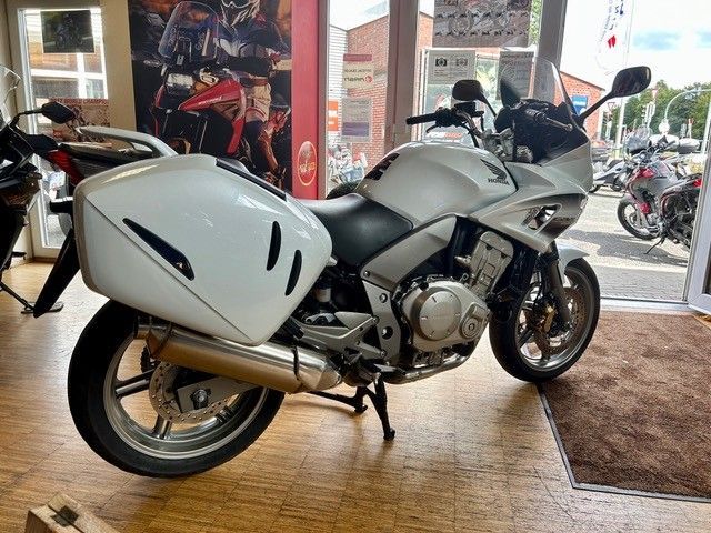Ein silbernes Sporttouring-Motorrad ist im Eingangsbereich eines Ausstellungsraums ausgestellt.