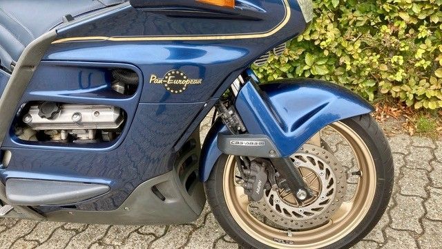 Blaues Honda Pan European Motorrad, goldene Akzente, Vorderrad sichtbar.