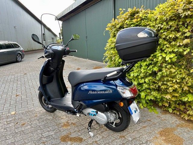 Ein blauer Roller steht vor einem Gebäude