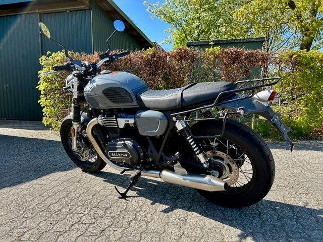 Ein Motorrad ist am Straßenrand vor einer Garage geparkt.