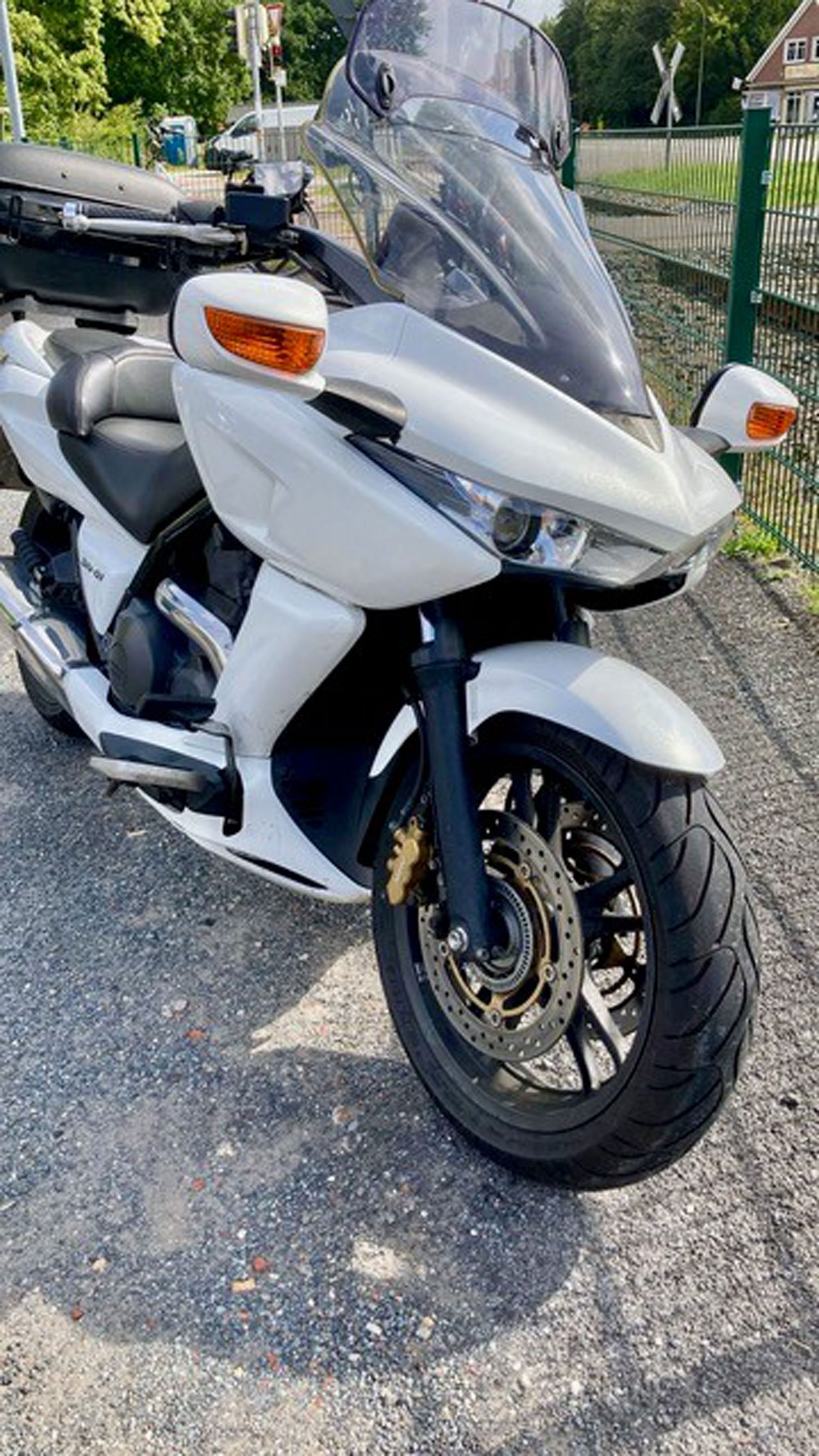 Weißes Tourenmotorrad im Freien geparkt.