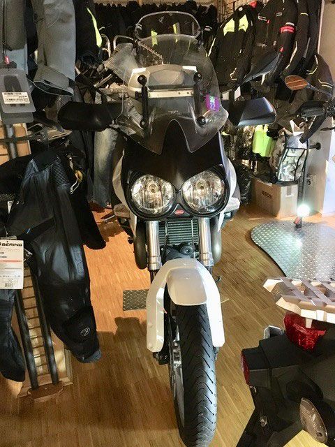 Ein schwarz-weißes Motorrad ist in einem Geschäft geparkt