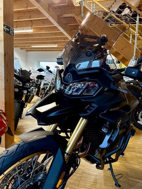 In einem Ausstellungsraum steht ein schwarzes Motorrad.