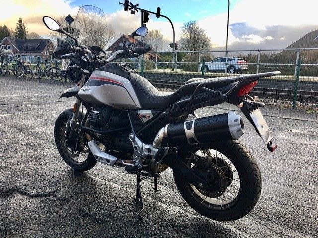 Auf einem Parkplatz steht ein Motorrad am Straßenrand.