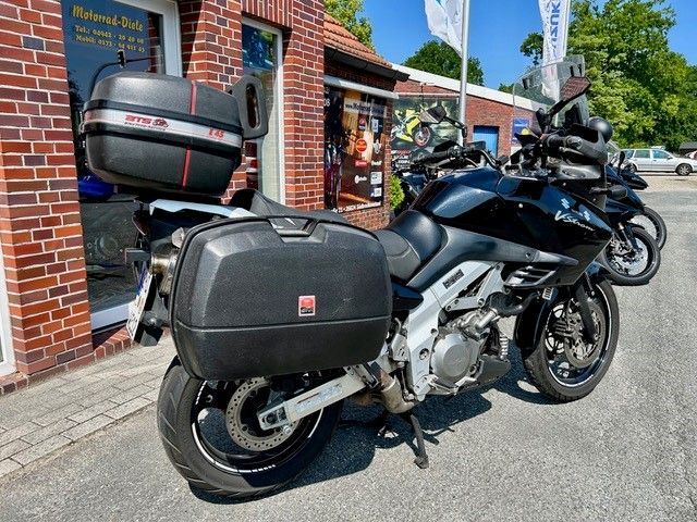 Ein schwarzes Motorrad steht vor einem Backsteingebäude