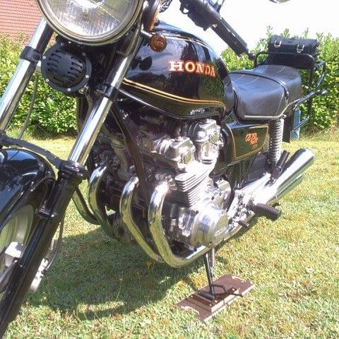 Ein schwarzes Honda-Motorrad ist im Gras geparkt