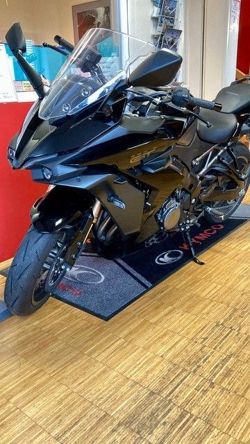 Schwarzes Sportmotorrad, das auf einem Teppich in einem Ausstellungsraum geparkt ist.