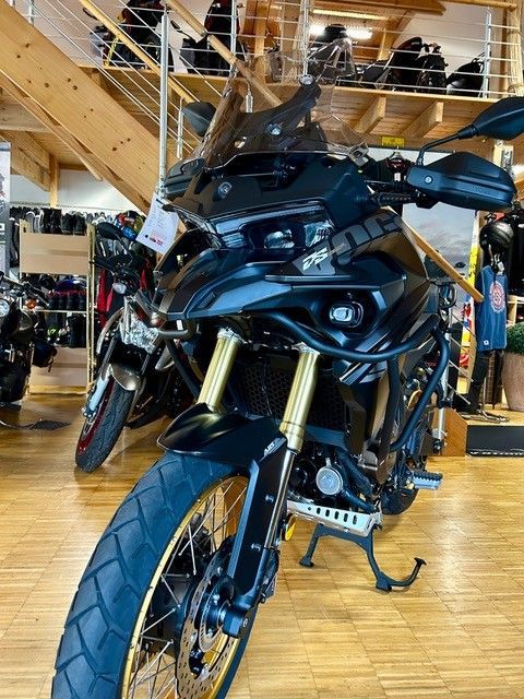 In einem Ausstellungsraum steht ein schwarzes Motorrad.