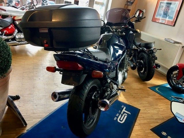 Ein Motorrad ist in einem Raum mit einer blauen Matte geparkt, auf der GT steht