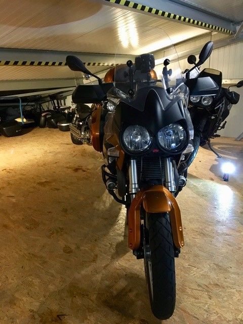 Ein schwarz-oranges Motorrad steht in einer Garage