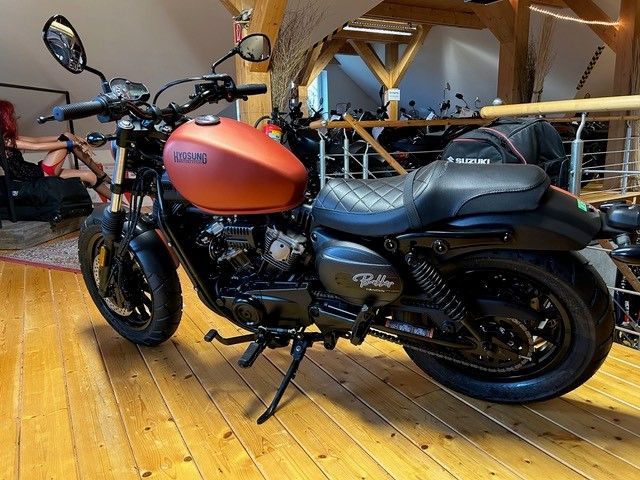 Ein Motorrad ist auf einem Holzboden in einem Raum geparkt.