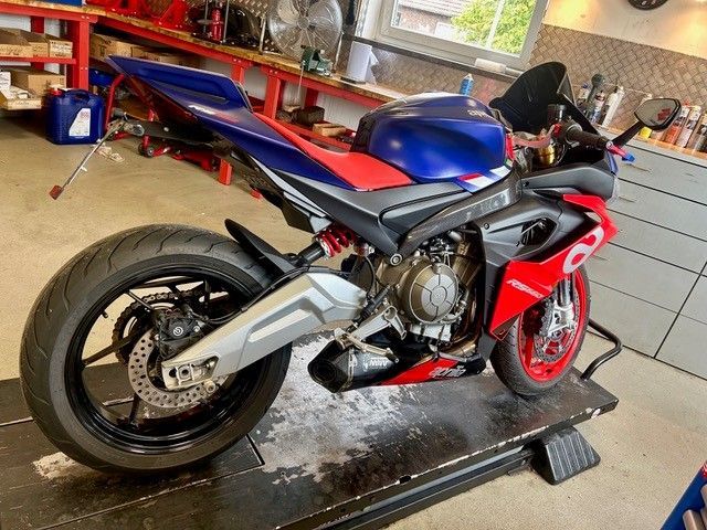 Blaues und rotes Sportmotorrad auf einem Ständer in einer Garage, Seitenansicht.