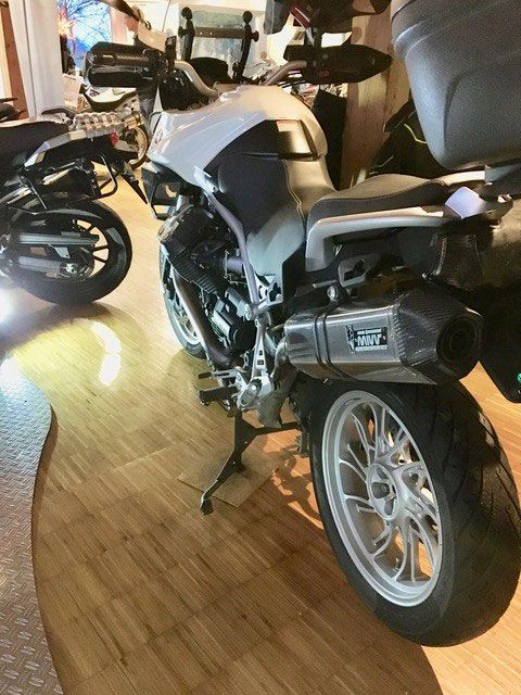 Ein Motorrad ist auf einem Holzboden in einem Raum geparkt.