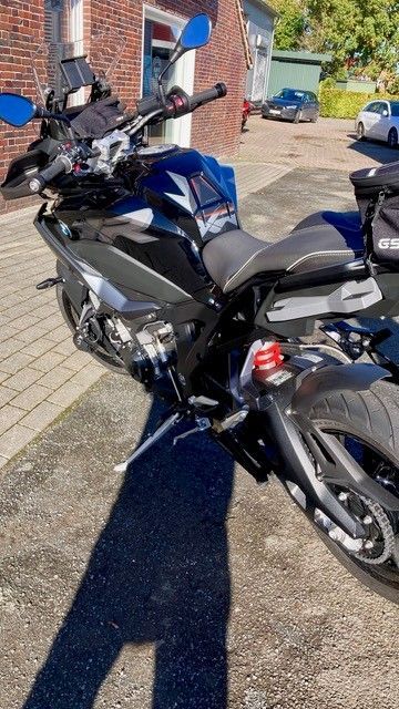 Schwarzes Motorrad, das an einem sonnigen Tag draußen geparkt ist.