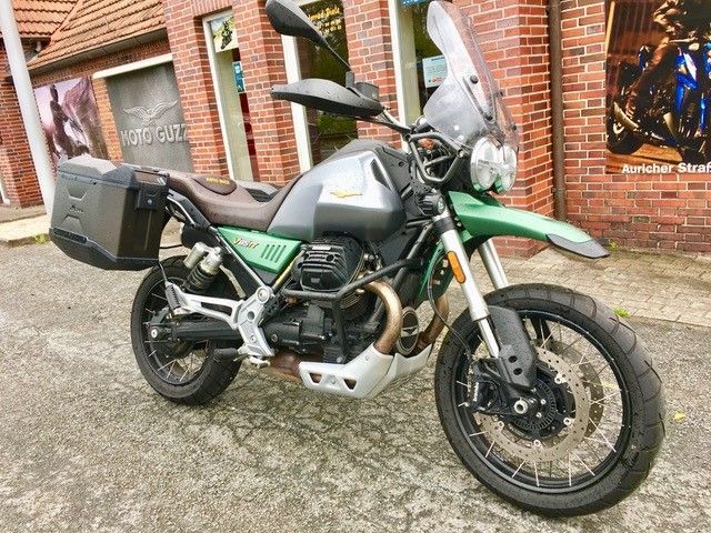 Vor einem Backsteingebäude ist ein Motorrad geparkt.