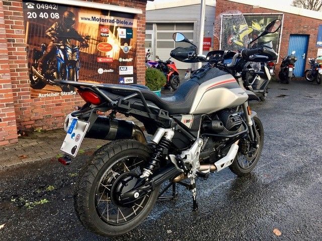 Vor einem Backsteingebäude ist ein Motorrad geparkt.