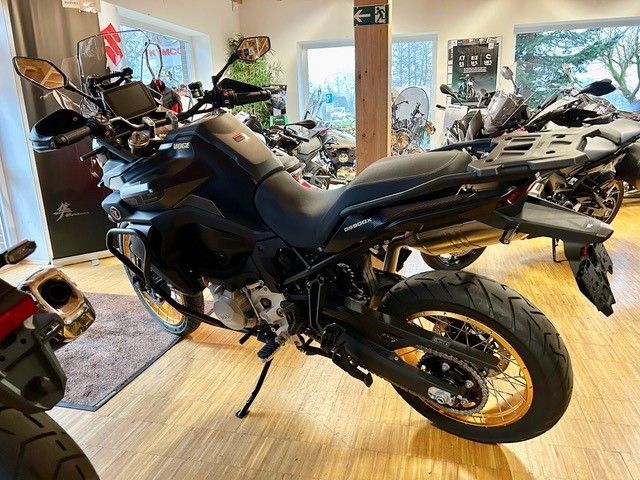 In einem Ausstellungsraum steht ein schwarzes Motorrad.