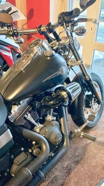 Ein schwarzes Harley-Davidson-Motorrad steht in einer Garage.